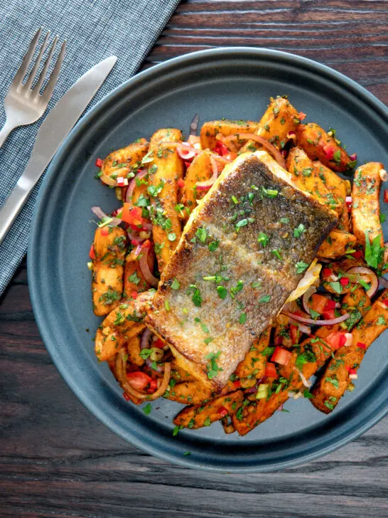 Overhead crispy skinned masala fish fillet (coley) served with masala chips.