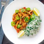 Overhead Mexican shredded chicken stew served with coriander rice and jalapenos.