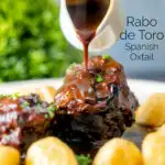 Rich gravy poured over rabo de toro or Spanish oxtail served with Parmentier potatoes featuring a title overlay.