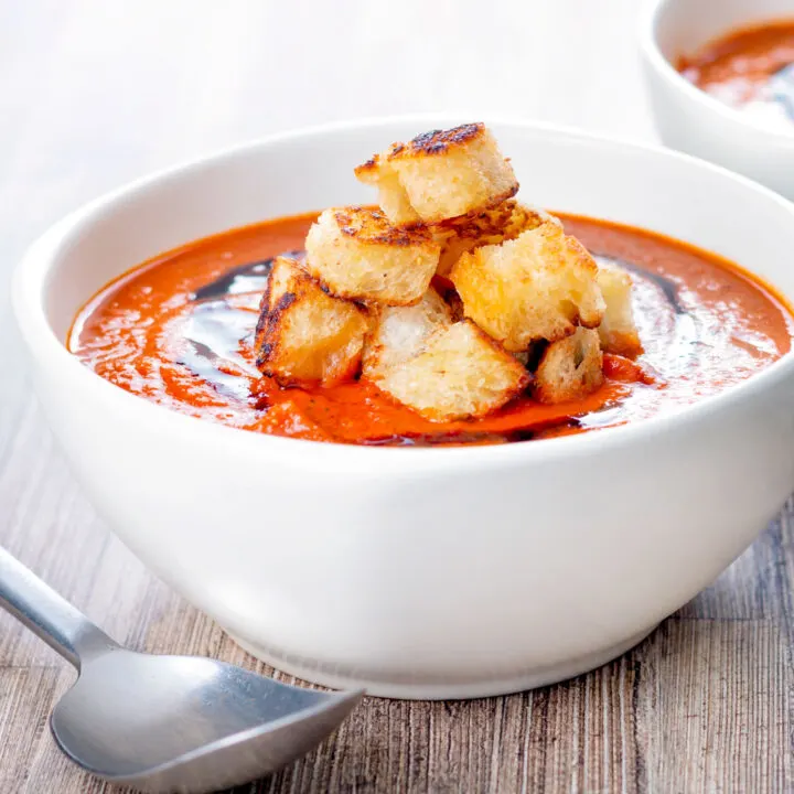 Homemade roasted garlic tomato soup with croutons and balsamic reduction.