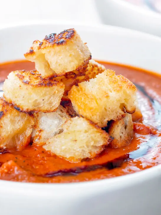 Close up garlic croutons served with homemade roasted garlic tomato soup.