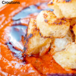 close up roasted tomato soup with garlic croutons and balsamic vinegar featuring a title overlay.