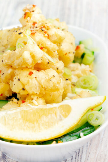 Crispy fried salt and pepper squid with a lemon wedge.