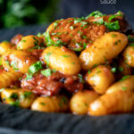 Easy sausage gnocchi in a tomato sauce with fresh parsley featuring a title overlay.