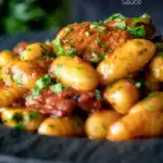 Easy sausage gnocchi in a tomato sauce with fresh parsley featuring a title overlay.