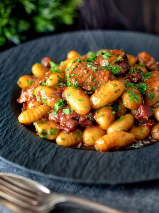 Steaming hot portion of sausage gnocchi in a tomato sauce.