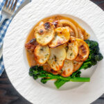 Overhead potato topped sausage hotpot with cider onion gravy served with broccoli.