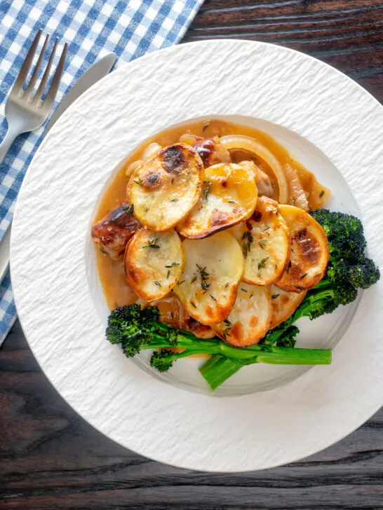 Overhead potato topped sausage hotpot with cider onion gravy served with broccoli.