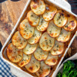 Overhead crispy scalloped potato topped sausage hotpot with cider onion gravy.