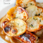 Close up potato topped sausage hotpot with cider onion gravy featuring a title overlay.