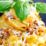 Close up slow cooker bolognese sauce served with tagliatelle pasta and fresh basil.