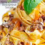 Close up slow cooker bolognese sauce served with tagliatelle pasta and parmesan featuring a title overlay.