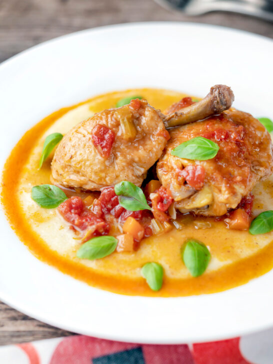 Lighter slow cooker chicken cacciatore served with cheesy polenta.