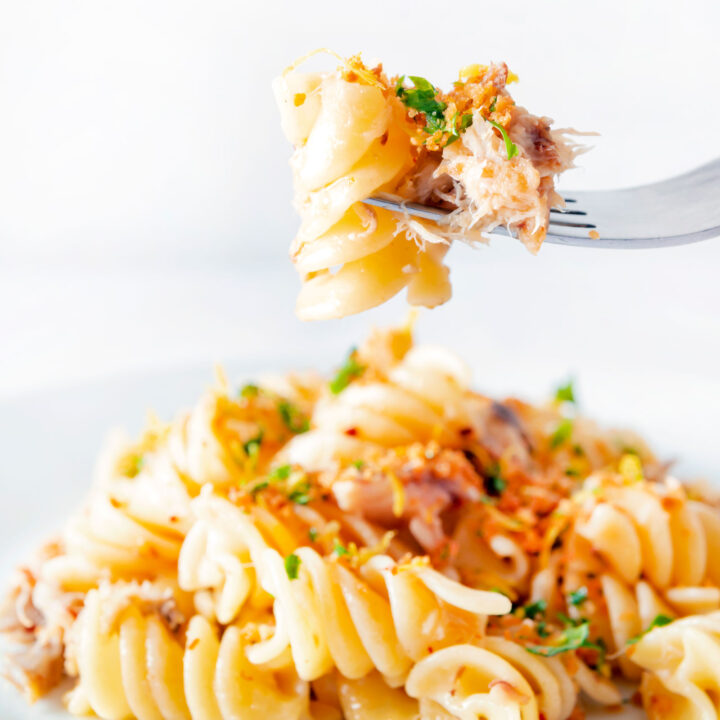 Spicy smoked mackerel pasta with fusilli, chilli, lemon and golden breadcrumbs on a fork.