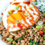 Close up of a sriracha fried egg served with Thai minced pork.