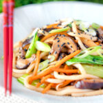 Vegan yaki udon noodles with shiitake mushrooms, carrots and pak choi.
