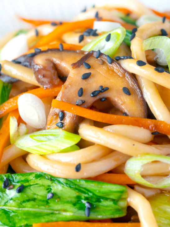 Close up Vegan yaki udon noodles with shiitake mushrooms, carrots and pak choi.
