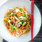 Overhead vegan yaki udon noodles with shiitake mushrooms, carrots and pak choi.