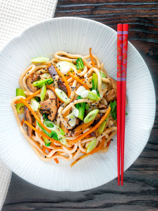 Overhead vegan yaki udon noodles with shiitake mushrooms, carrots and pak choi.