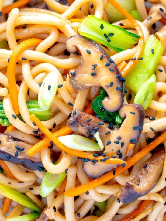 Overhead close up yaki udon noodles with shiitake mushrooms, carrots and pak choi.