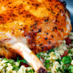 Clos up rose harissa glazed roasted pork chops with bulgur wheat salad featuring a title overlay.