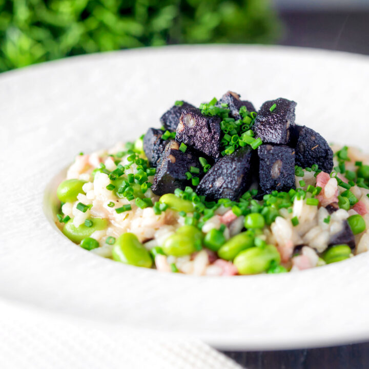 Black pudding risotto with bacon, broad beans and garden peas with snipped chives.