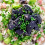 Overhead close up black pudding risotto with bacon, broad beans and garden peas.