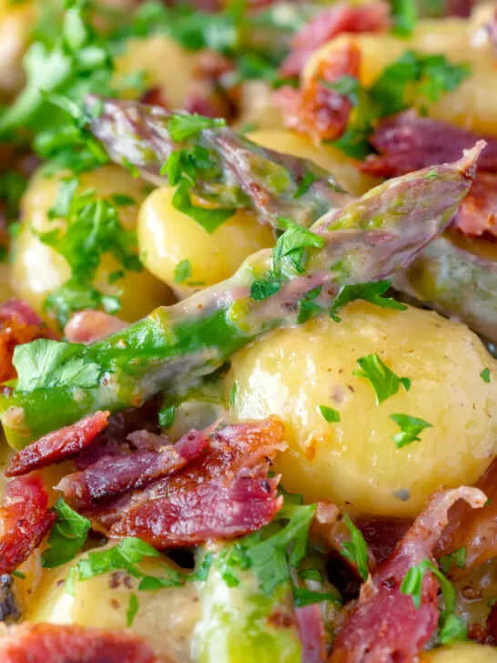 Close up creamy blue cheese gnocchi with stilton, asparagus and bacon.