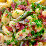Close up overhead creamy blue cheese gnocchi with stilton, asparagus and bacon.