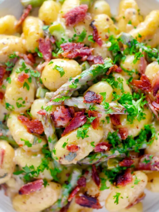 Close up overhead creamy blue cheese gnocchi with stilton, asparagus and bacon.