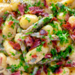 Close up overhead creamy blue cheese gnocchi with stilton, asparagus and bacon featuring a title overlay.