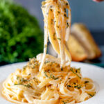 Blue cheese pasta with fettuccini and a crispy golden sage crumb being eaten with a fork.
