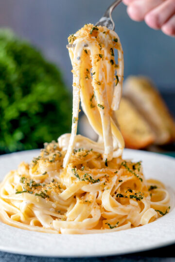 Blue cheese pasta with fettuccini and a crispy golden sage crumb being eaten with a fork.