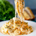 Blue cheese pasta with fettuccini and a crispy golden sage crumb being eaten with a fork featuring a title overlay.