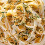 Close up overhead blue cheese pasta with fettuccini and a crispy golden sage crumb featuring a title overlay.