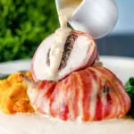 Whisky cream sauce poured over bacon-wrapped chicken Balmoral stuffed with haggis.