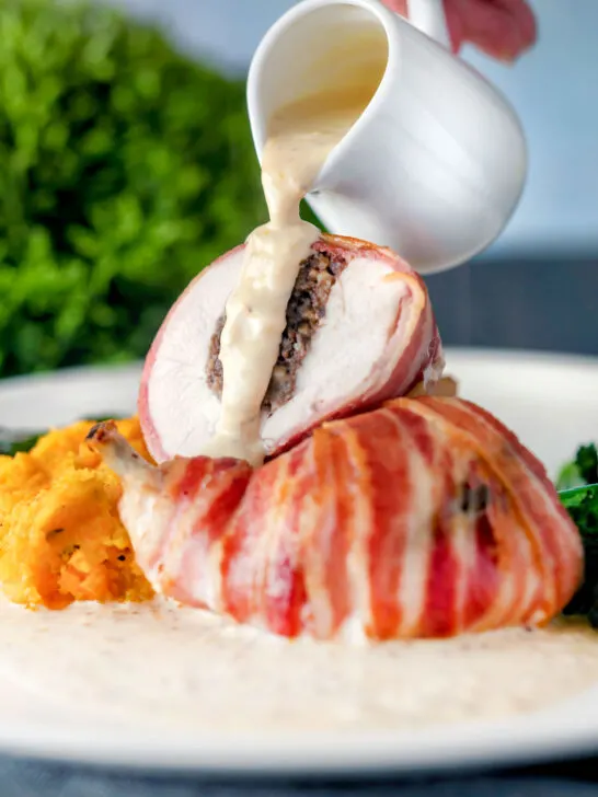 Whisky cream sauce poured over bacon-wrapped chicken Balmoral stuffed with haggis.