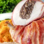 Close-up bacon-wrapped chicken Balmoral stuffed with haggis and a whisky cream sauce.