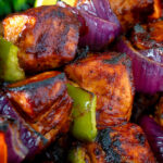 Close up chicken shashlik kebab sticks with peppers and onions.