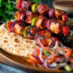 Spicy chicken shashlik kebab sticks with chapatis and kachumber salad featuring a title overlay.