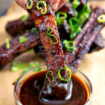 Chinese takeaway style spare ribs dipped into sauce.