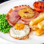 Gammon steak, pineapple, egg, chips with tomato and peas.