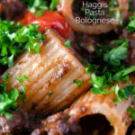 Close up haggis pasta bolognese with mezzi rigatoni in red wine sauce with cherry tomatoes featuring a title overlay.