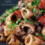 Haggis pasta bolognese with mezzi rigatoni with cherry tomatoes featuring a title overlay.