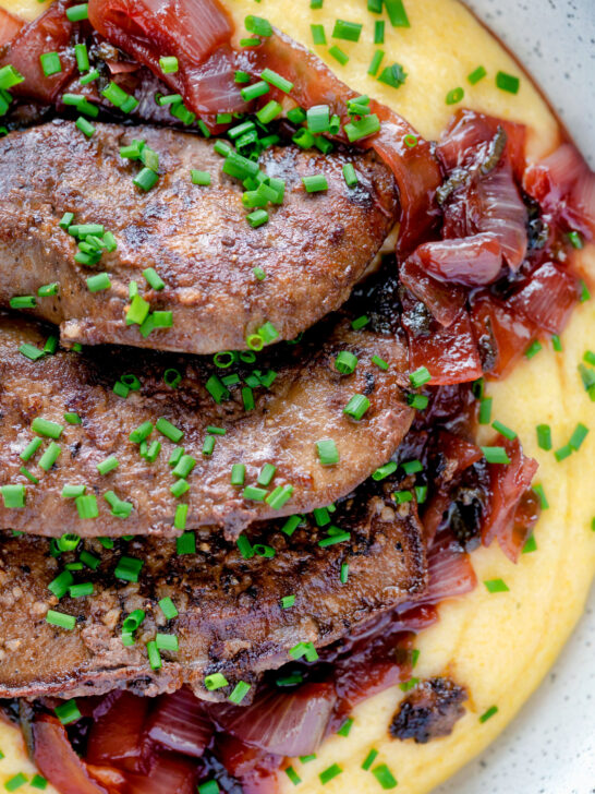 Close up overhead fried lambs liver and port onions on polenta.