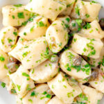 Close up overhead ricotta cheese gnocchi with caper butter sauce.