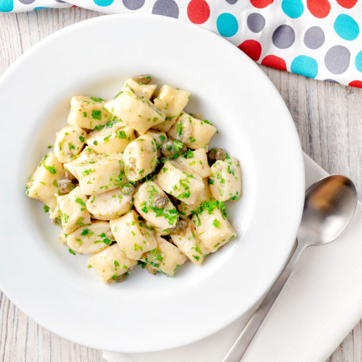 Homemade ricotta cheese gnocchi with parsley and caper butter sauce.