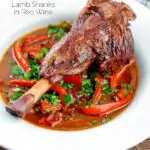 Slow cooker braised lamb shanks in a red wine, tomato, garlic and pepper sauce featuring a title overlay.