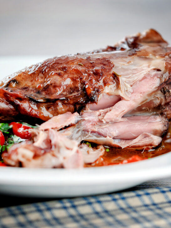 Detail of cooked meat from slow cooked lamb shanks in red wine sauce.