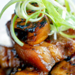 Close up sticky pork belly with pineapple and soy sauce served with rice.